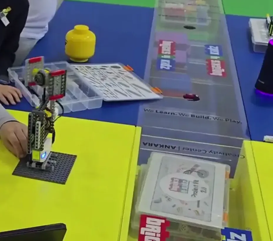 Öğrenci LEGO robot modeli üzerinde çalışıyor