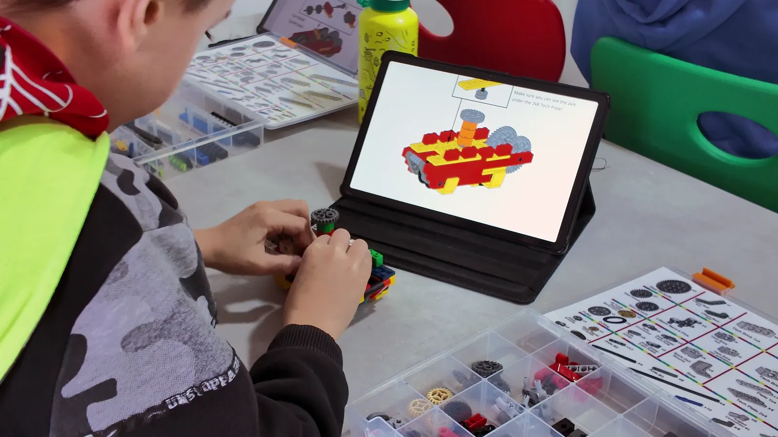 Çocuk tablet üzerindeki talimatlarla LEGO model inşa ediyor